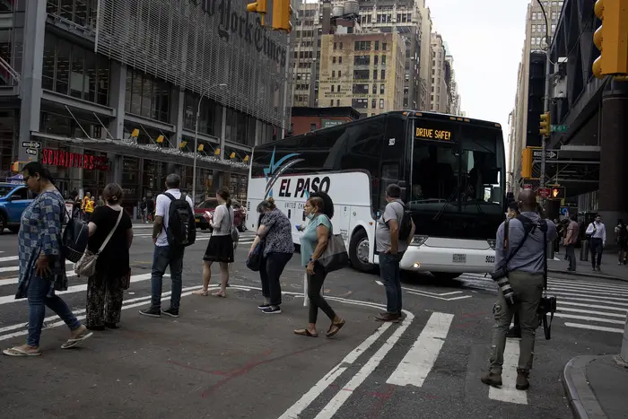 A bus with the words "El Paso" turns the corner of a midtown street.